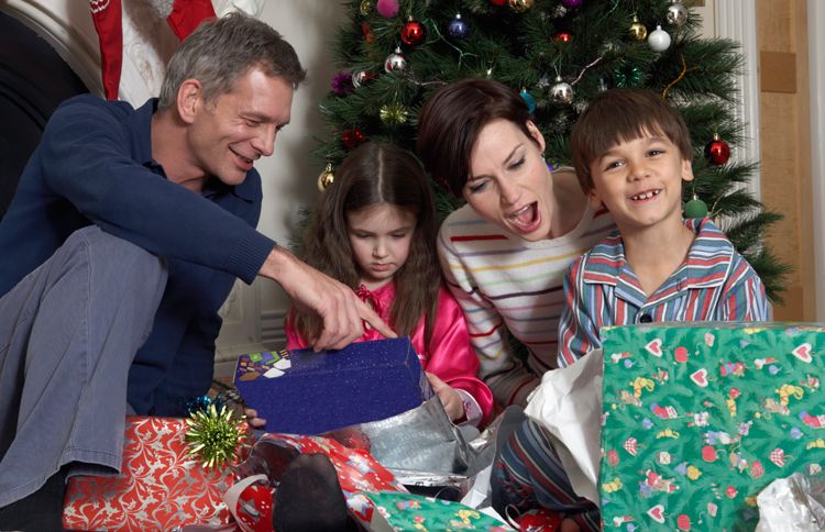 The smiling members of a family open their presents of Christmas quotes on Christmas morning