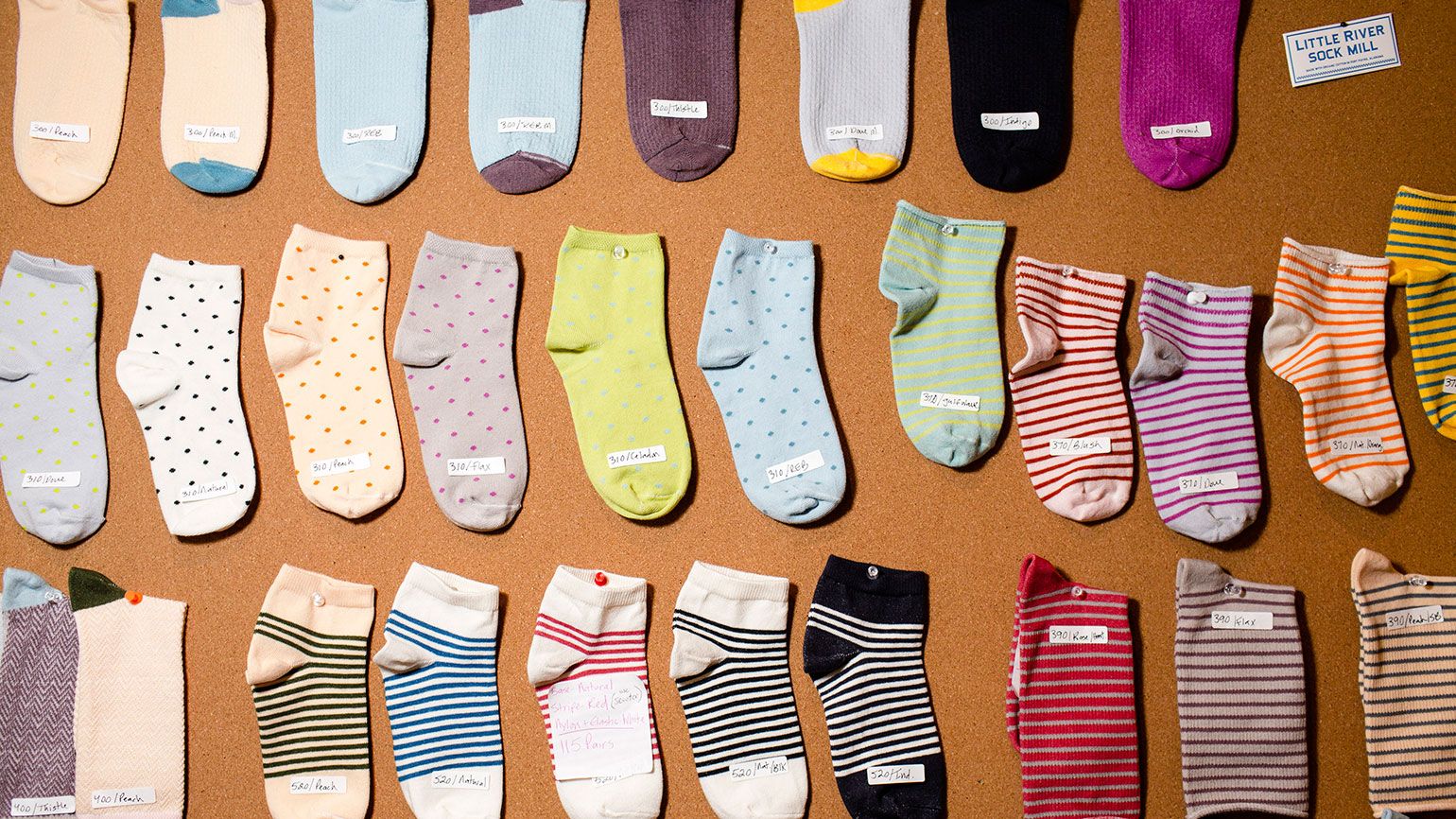 A board of socks hangs in Gina's office. Gina has transformed her parents' sock business, at the Emi-G Knitting mill in Fort Payne, Alabama.