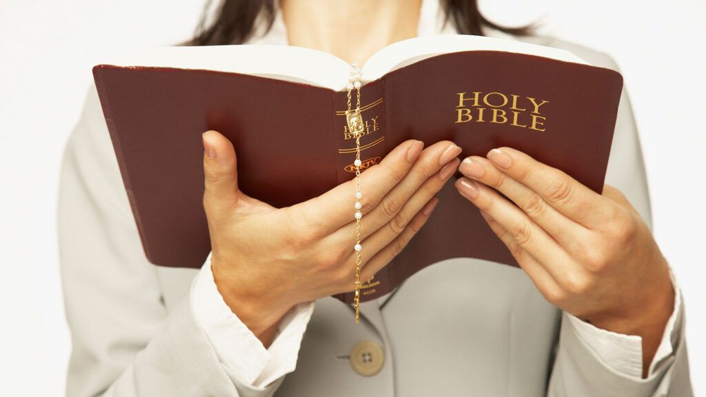 A woman's hands holding an open Bible
