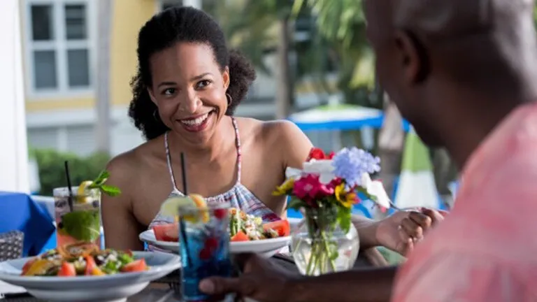 Couple talking about their finances over food and drinks.