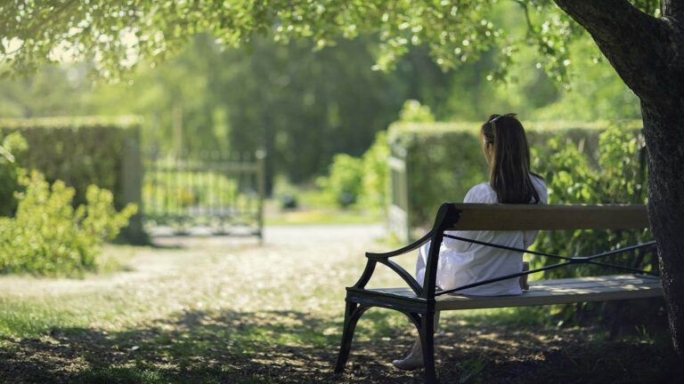 Woman sitting on a park bench during spring