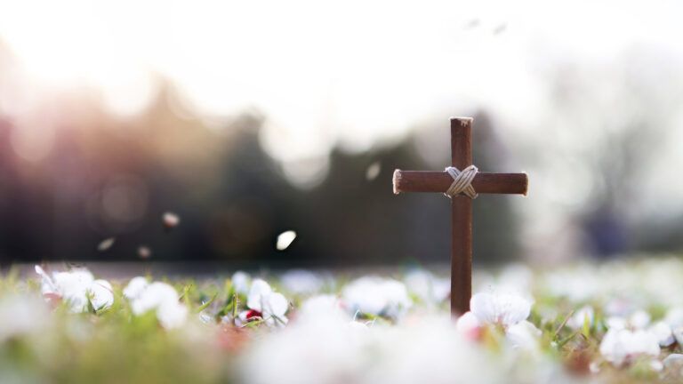 Wooden cross surrounded by spring flowers during Lent