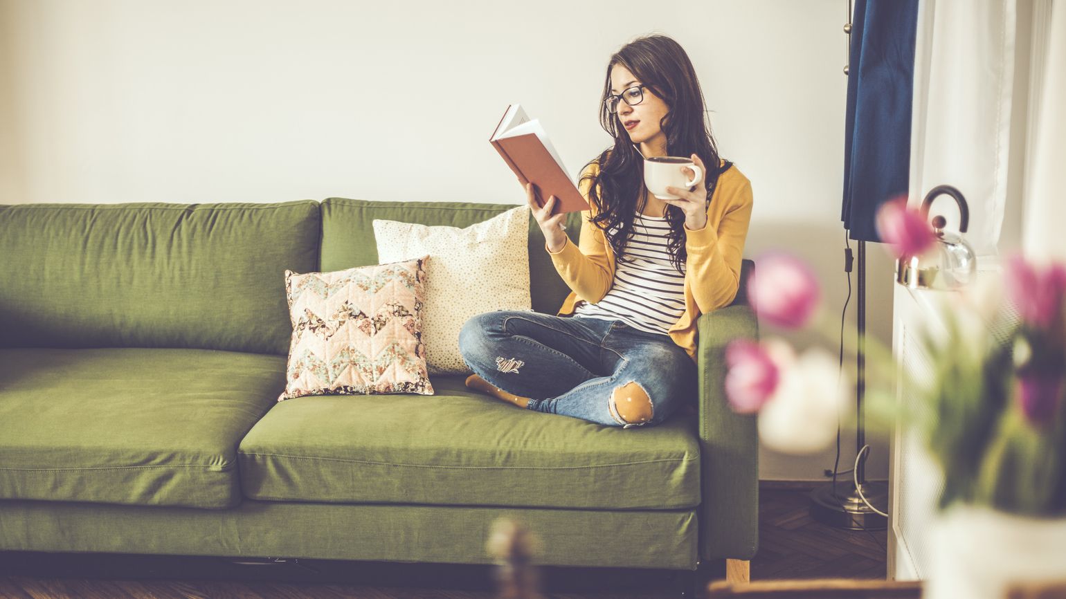 https://guideposts.org/wp-content/uploads/2017/03/Young-woman-reading-the-book-of-Bible-verses-about-spring-with-tulips-in-her-home.jpg.optimal.jpg