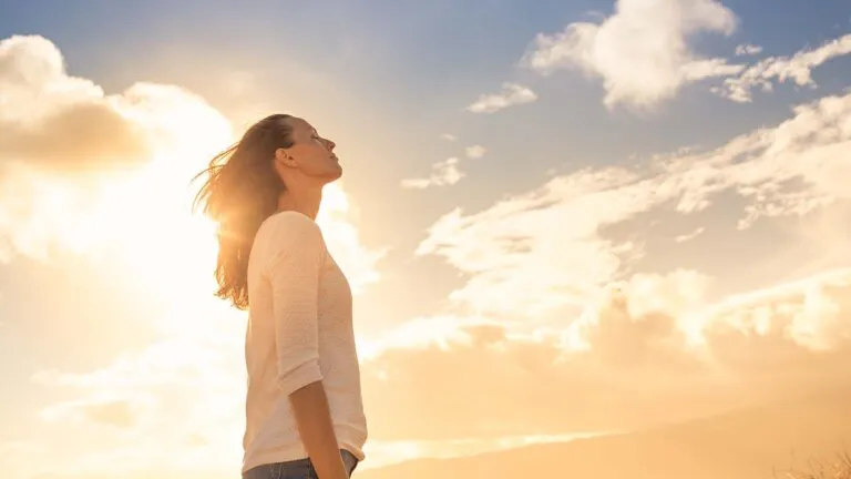 Woman looking up at the sky and praying her Holy Week prayers