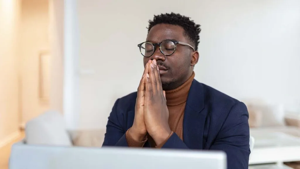 man siting at his desk doing his holy week prayers