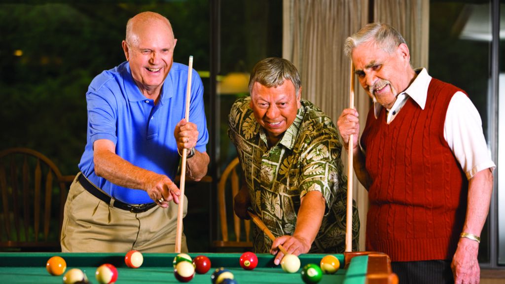 Three senior citizens playing pool