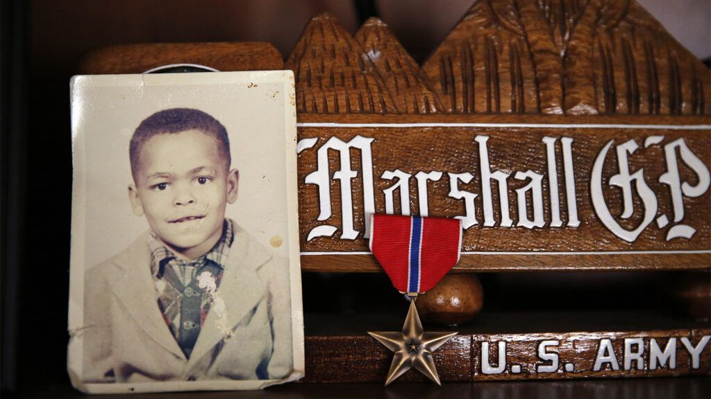 Iraq Veteran's Journey of Healing: A childhood photo of Sgt. Powell rests alongside the Bronze Star he earned in Iraq at his home in Crescent, Oklahoma.