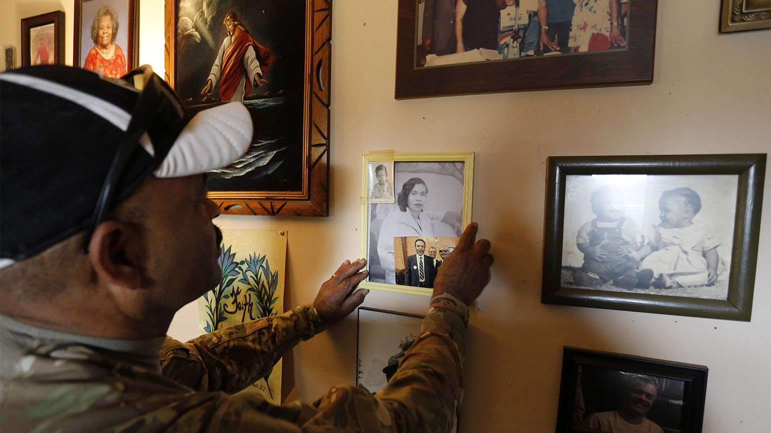 Iraq Veteran's Journey of Healing: Sgt. Powell straightens a photo of his mother on a wall at his brother's house