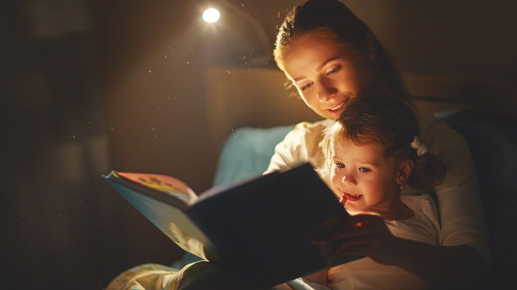 A young mother reading a bedtime story to her daughter.