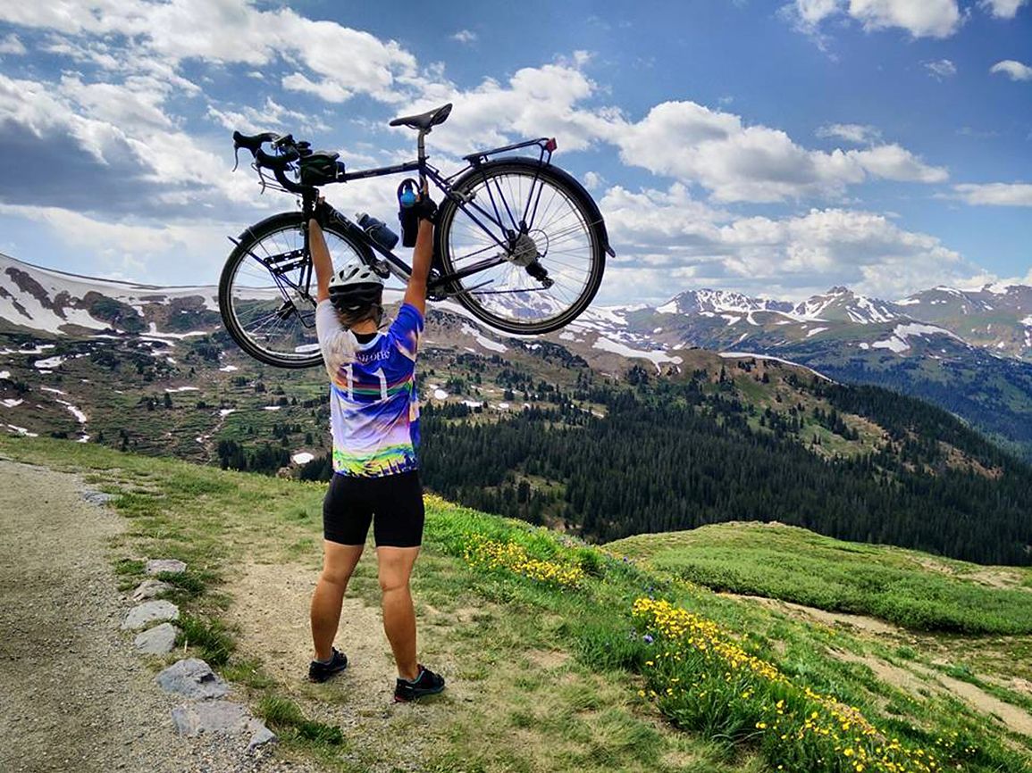 Deborah raises her bike in jubilation at having conquered the challenging Loveland Pass in Colorado.