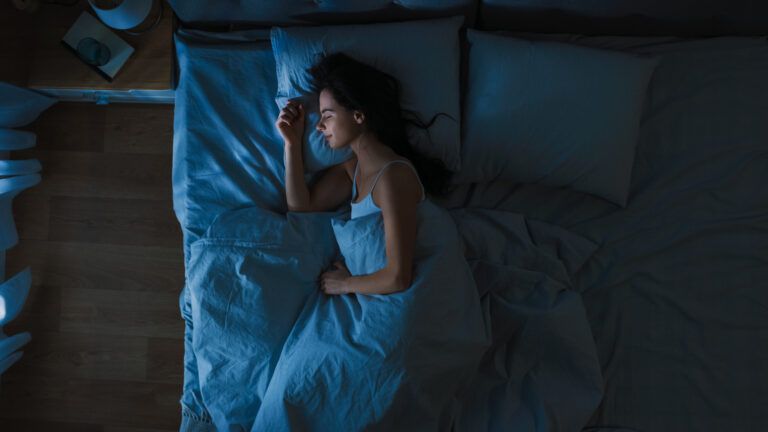 Woman sleeping in bed after reading bible verses for a good night sleep