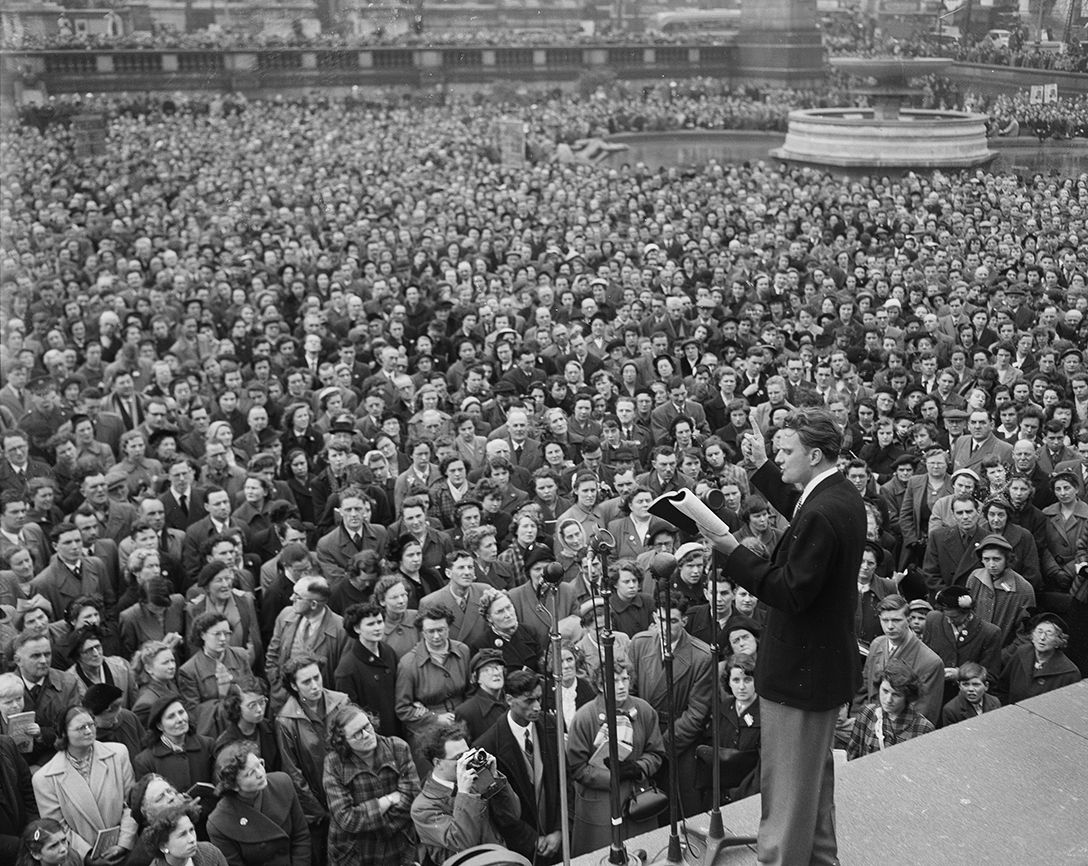 Graham reads passages from the Bible to a large, rapt audience in Trafalgar Square, London, on April 12, 1954.