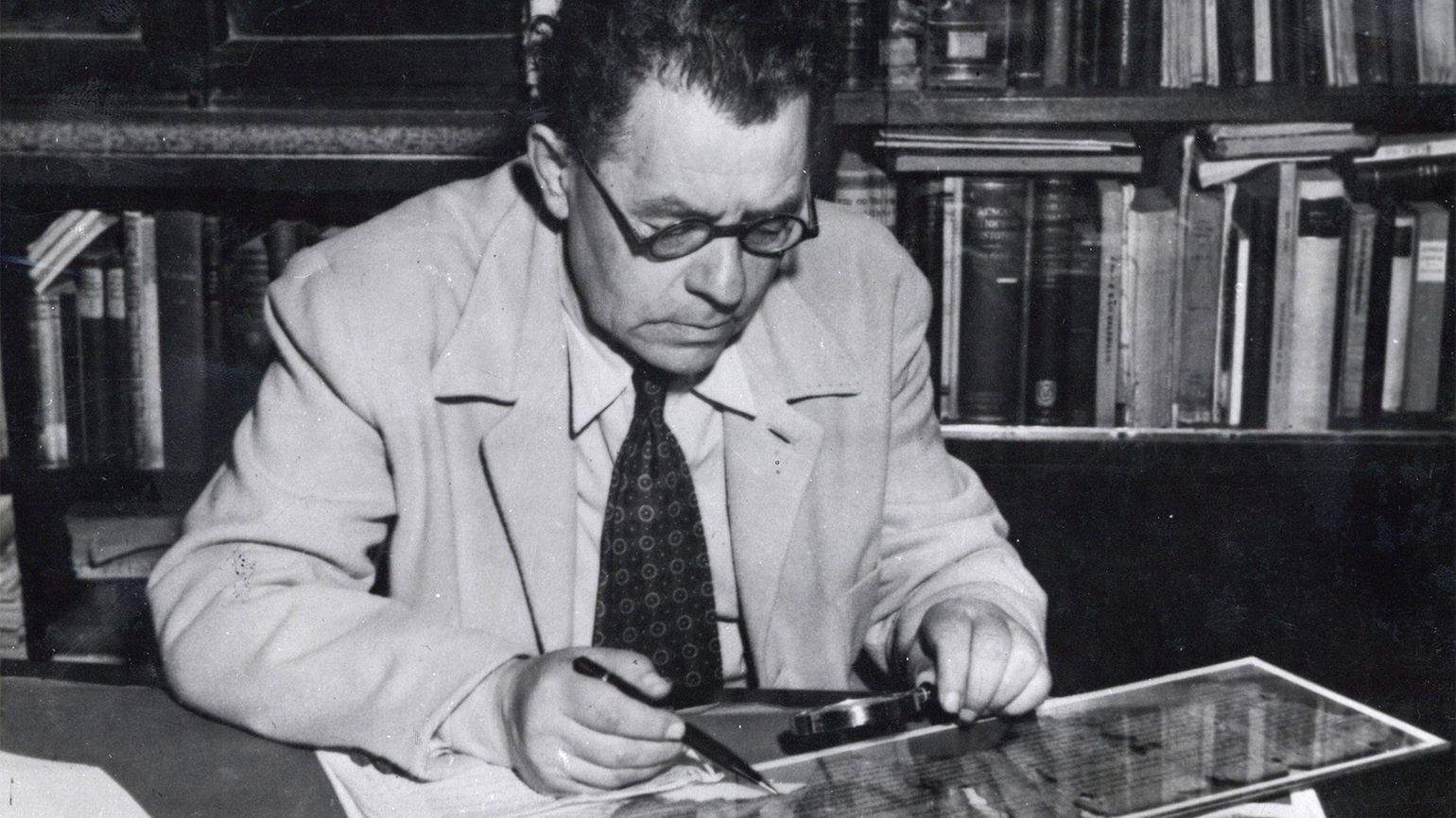 Scholar Eleazar Sukenik examining one of the Dead Sea Scrolls in 1951