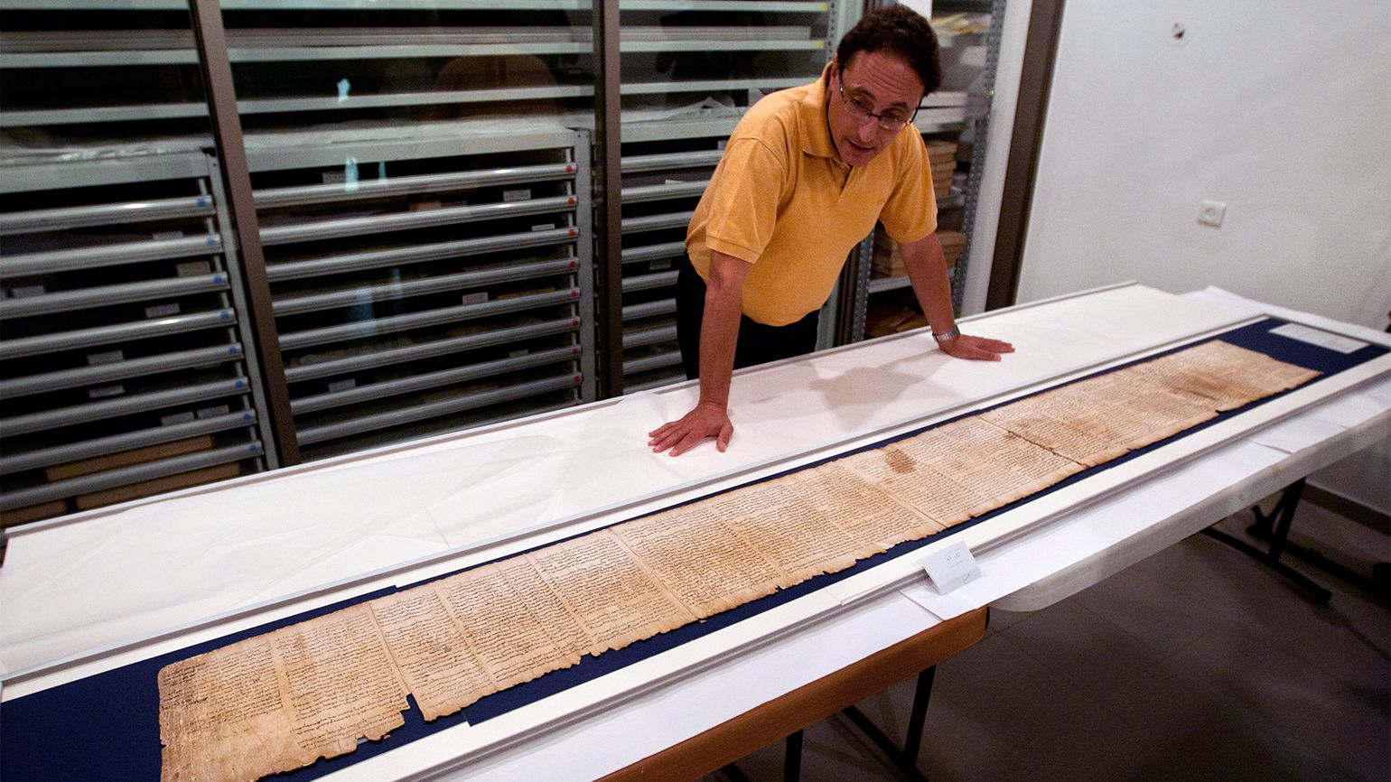 A researcher looks over a scroll fragment