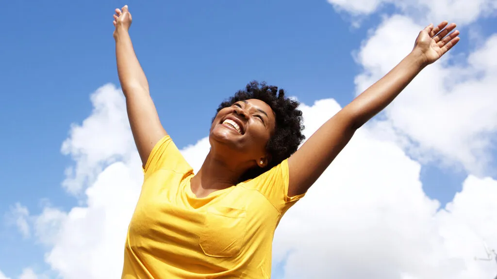 A happy woman raises her hands in joy