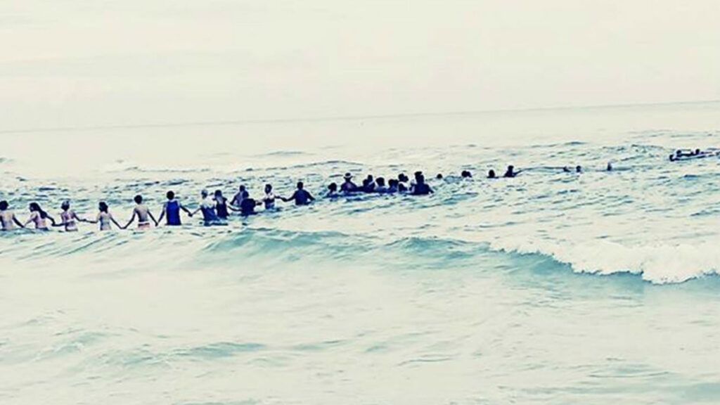 80 person human chain forms to save family on beach