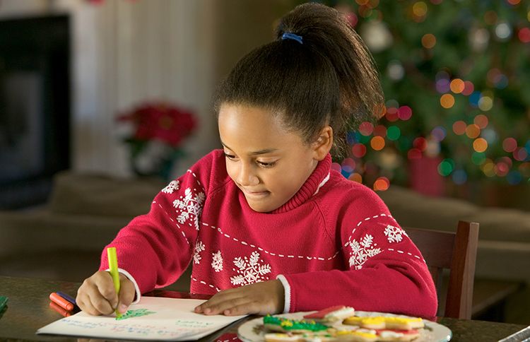 A young girl composes a letter to Santa Claus