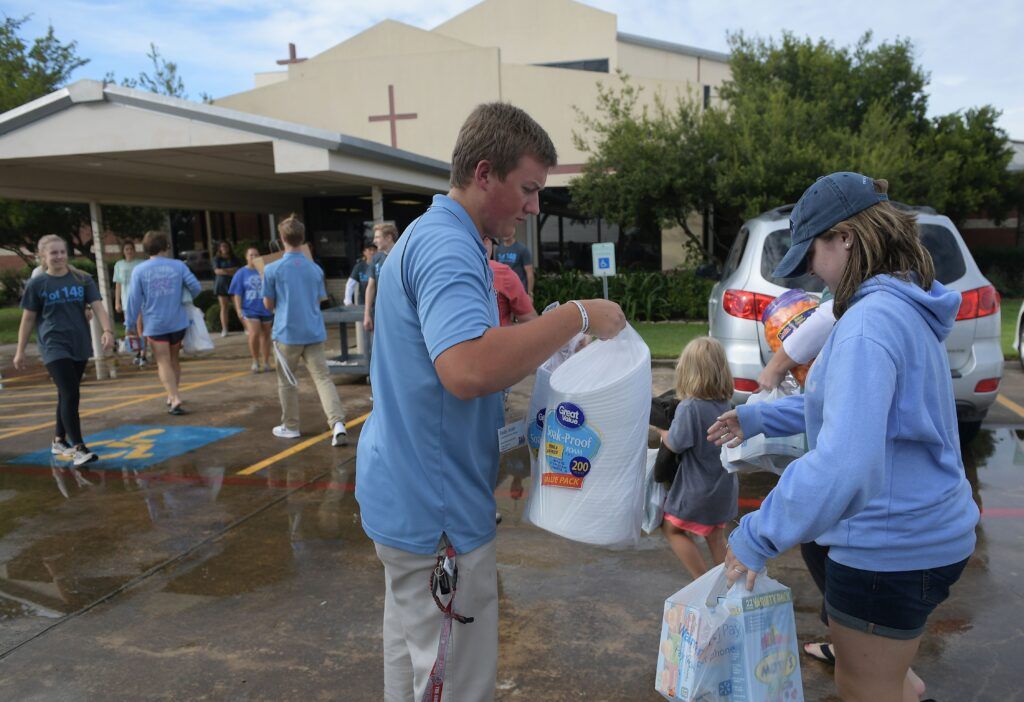 A volunteer receives donated items outside of a shelter for volunteer rescue workers set up at the Fairfield Baptist Church