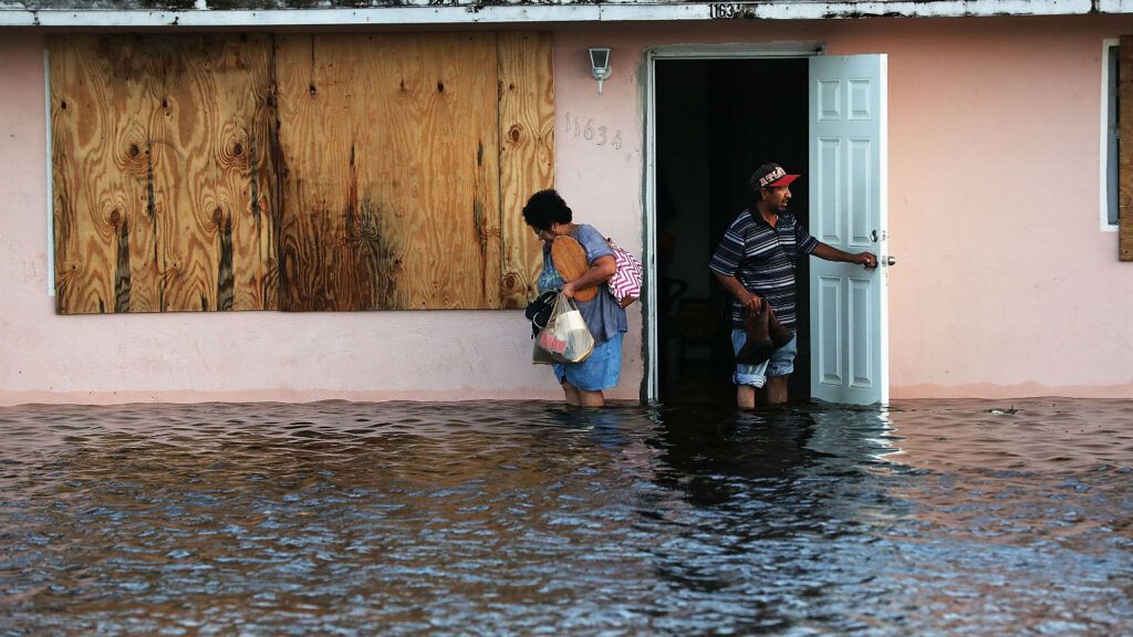 A couple leave their flooded home the morning after Hurricane Irma