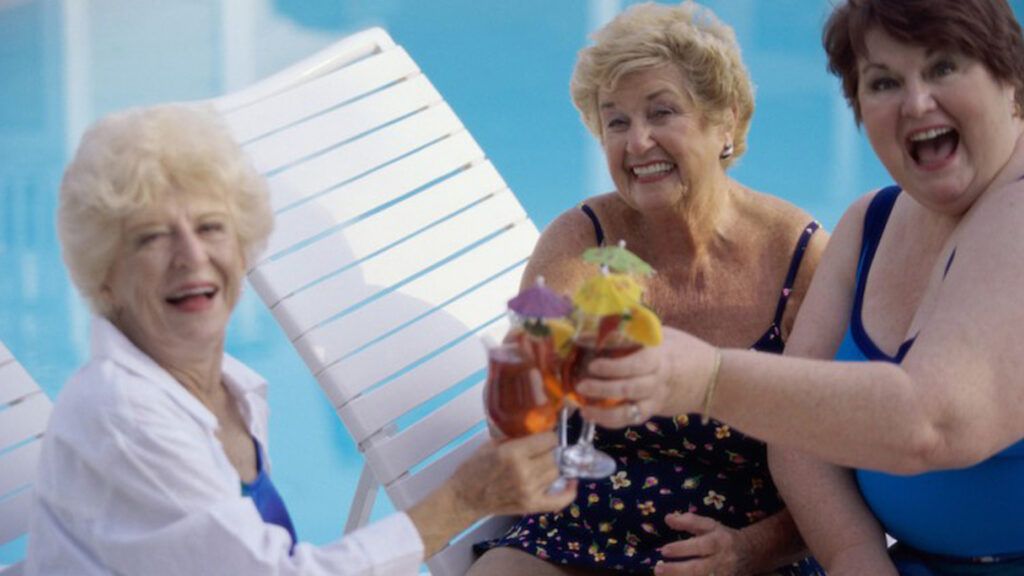 A group of senior citizen women enjoying themselves by the pool side.
