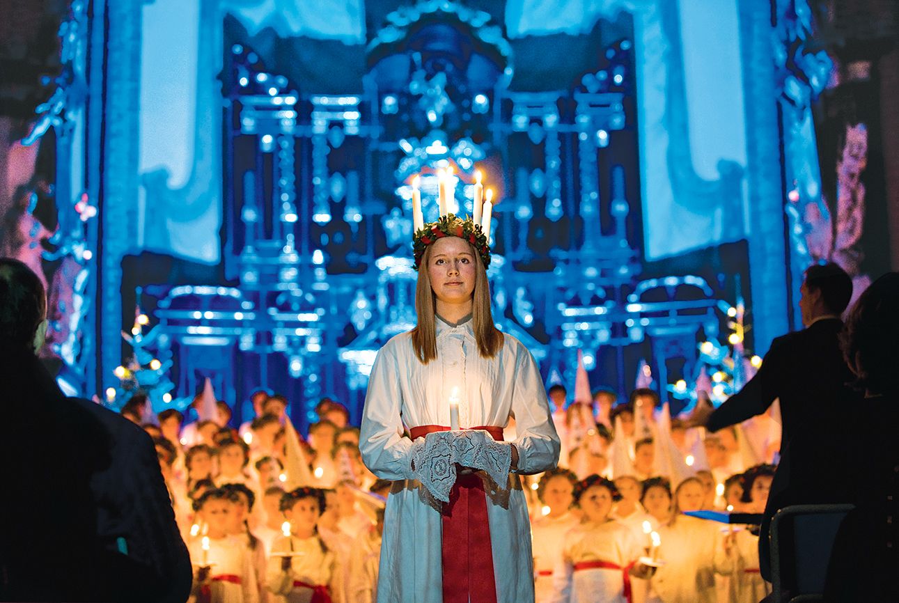 A young Swedish girl in a candlelit crown portrays St. Lucia