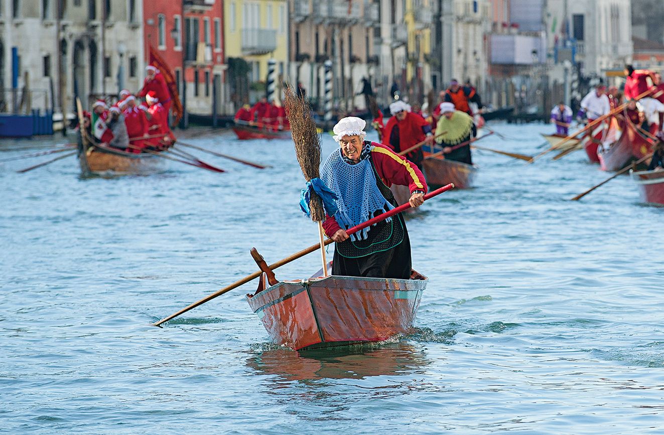 A man dressed as La Befana partcipates in the holiday boat race on Venice's Grand Canal