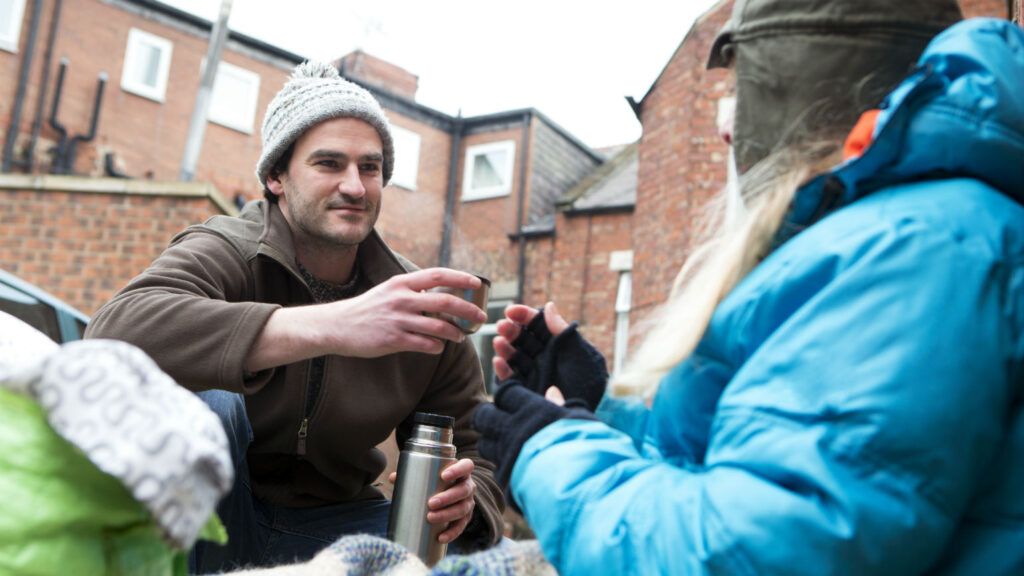 Man helping homeless woman