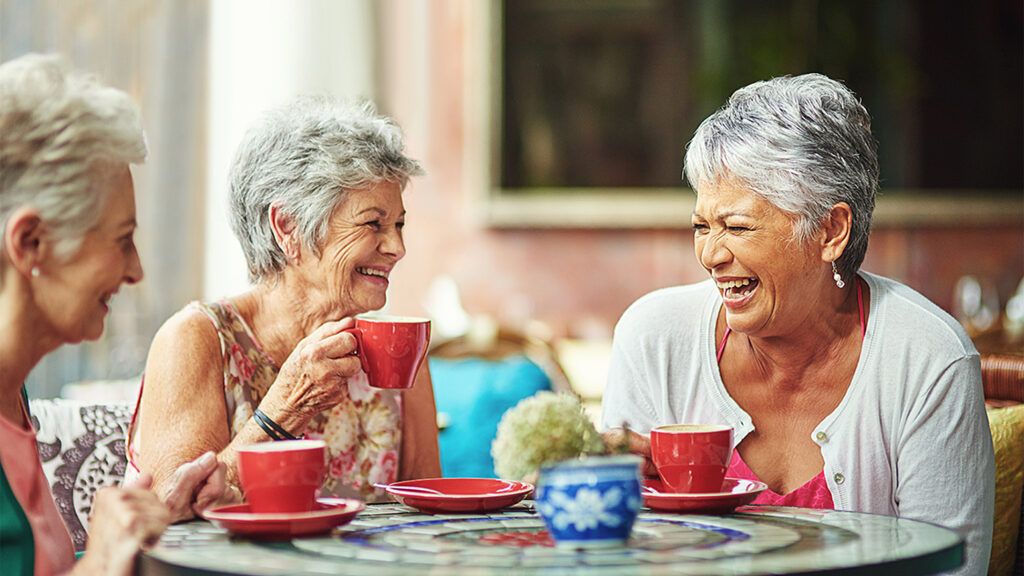 Senior women laughing over coffee