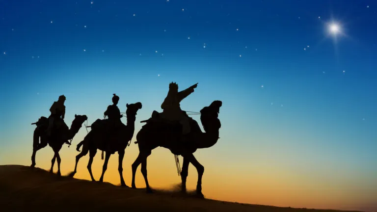 The wise men in silhouette pointing to the north star in a christmas story of hope