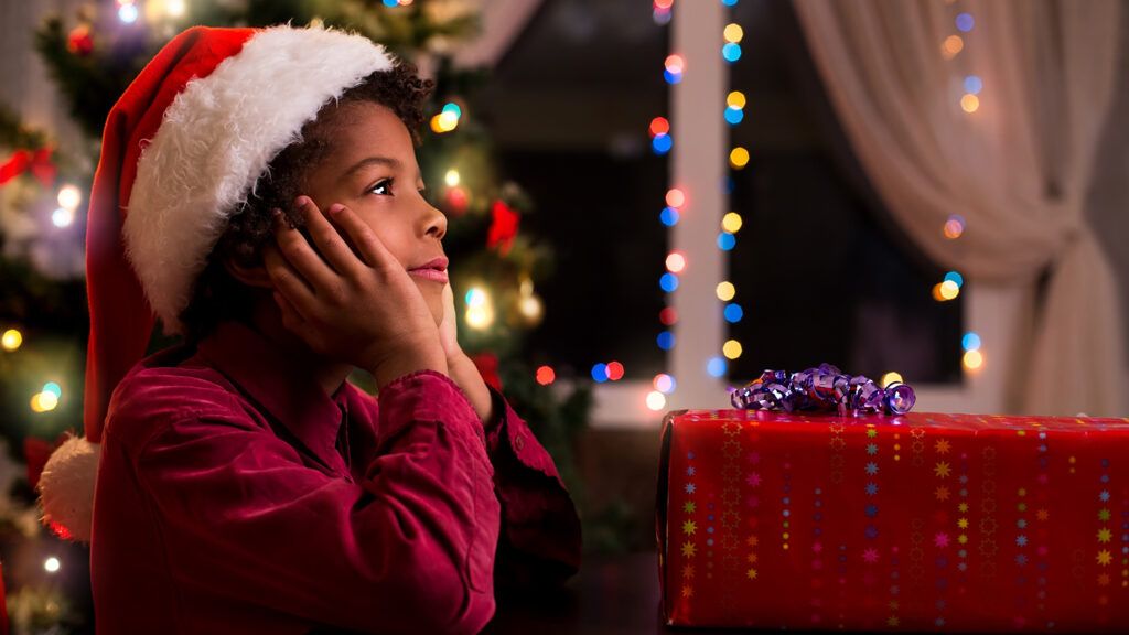 A child in a Santa hat exhibits the wonder of the holidays