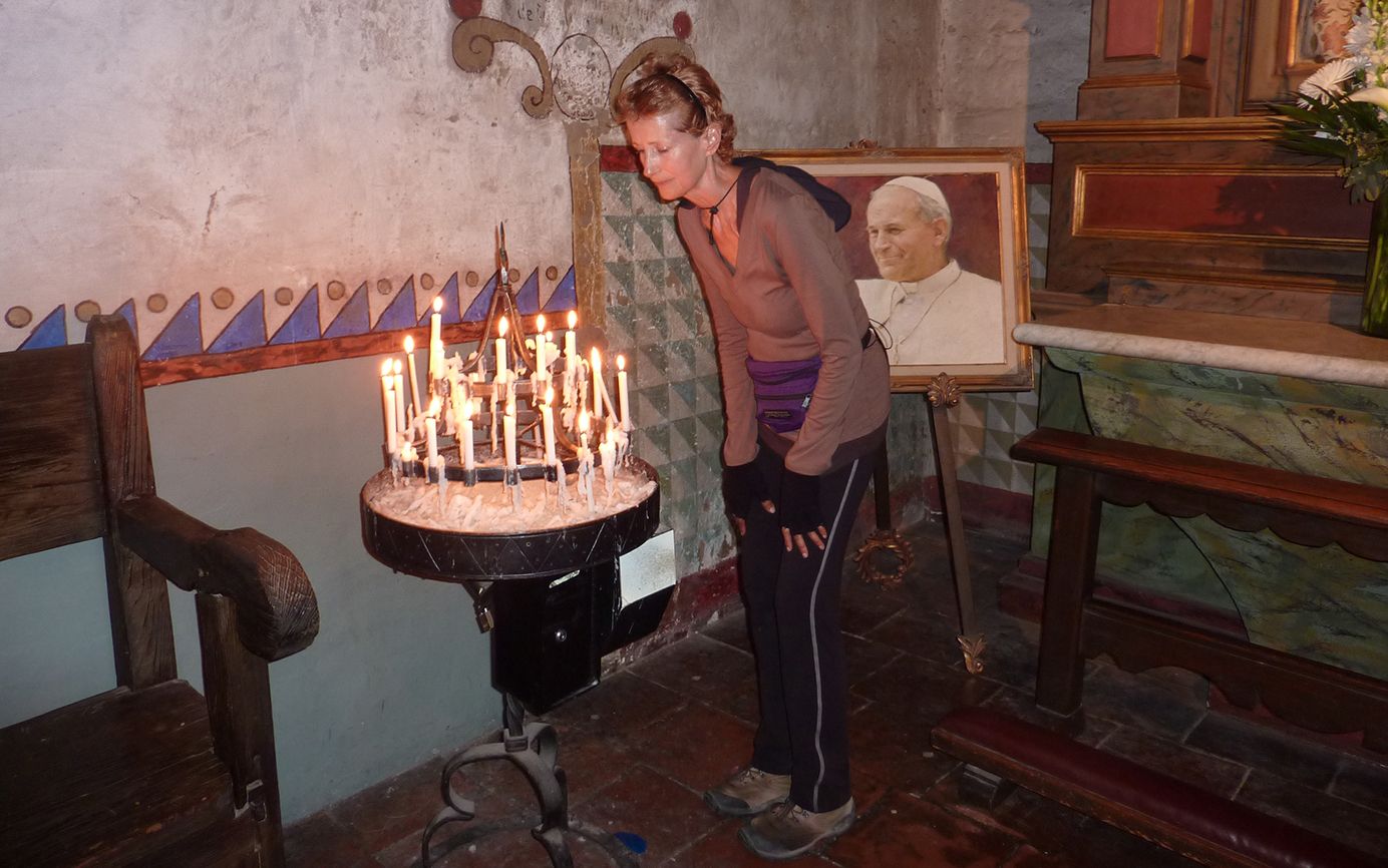 Day 40: Edie lights a candle at Mission Carmel.