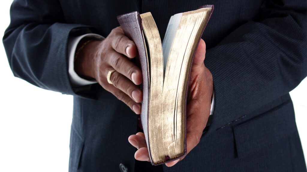 A man clasps a Bible