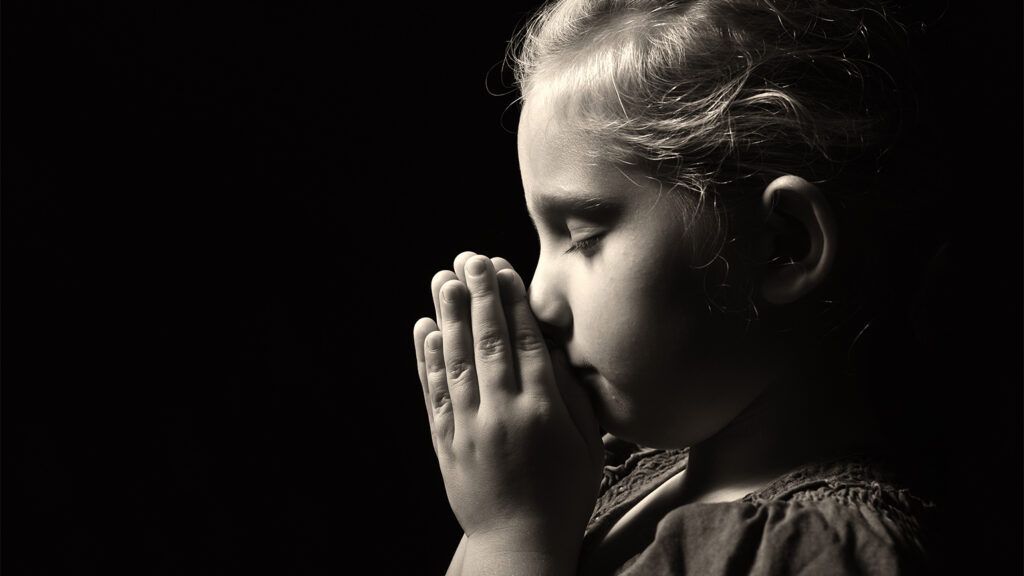 A young girl prays