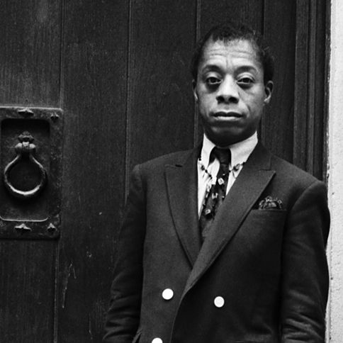 James Baldwin standing next to a door saying Black History Month quotes
