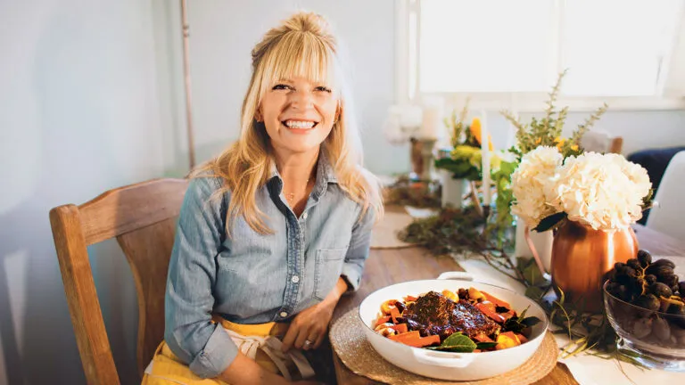 Bri sits at a kitchen table, her favorite pot roast at her side