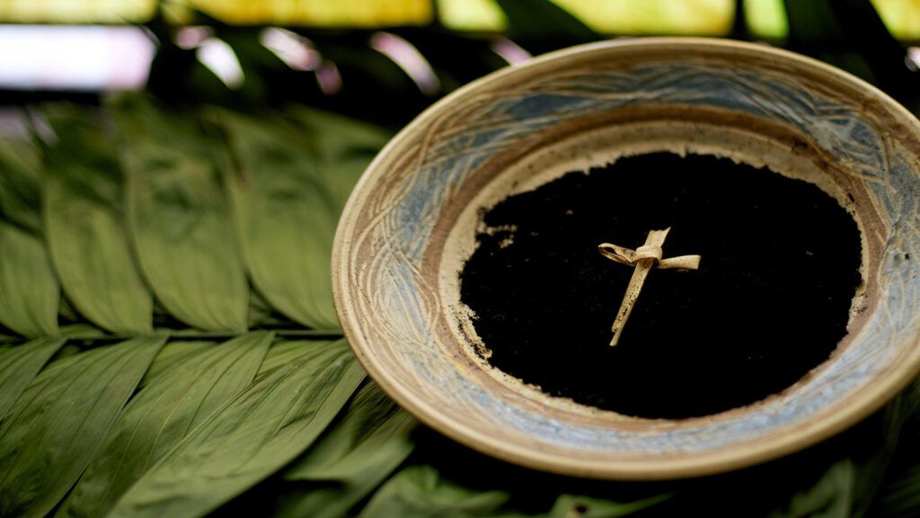 A bowl of ashes for Ash Wednesday, resting on a bed of palm branches