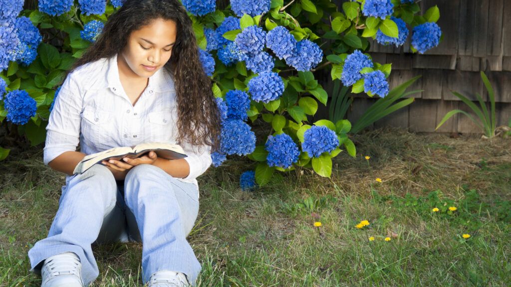 Woman sitting outside reading the Bible for her Lenten journey