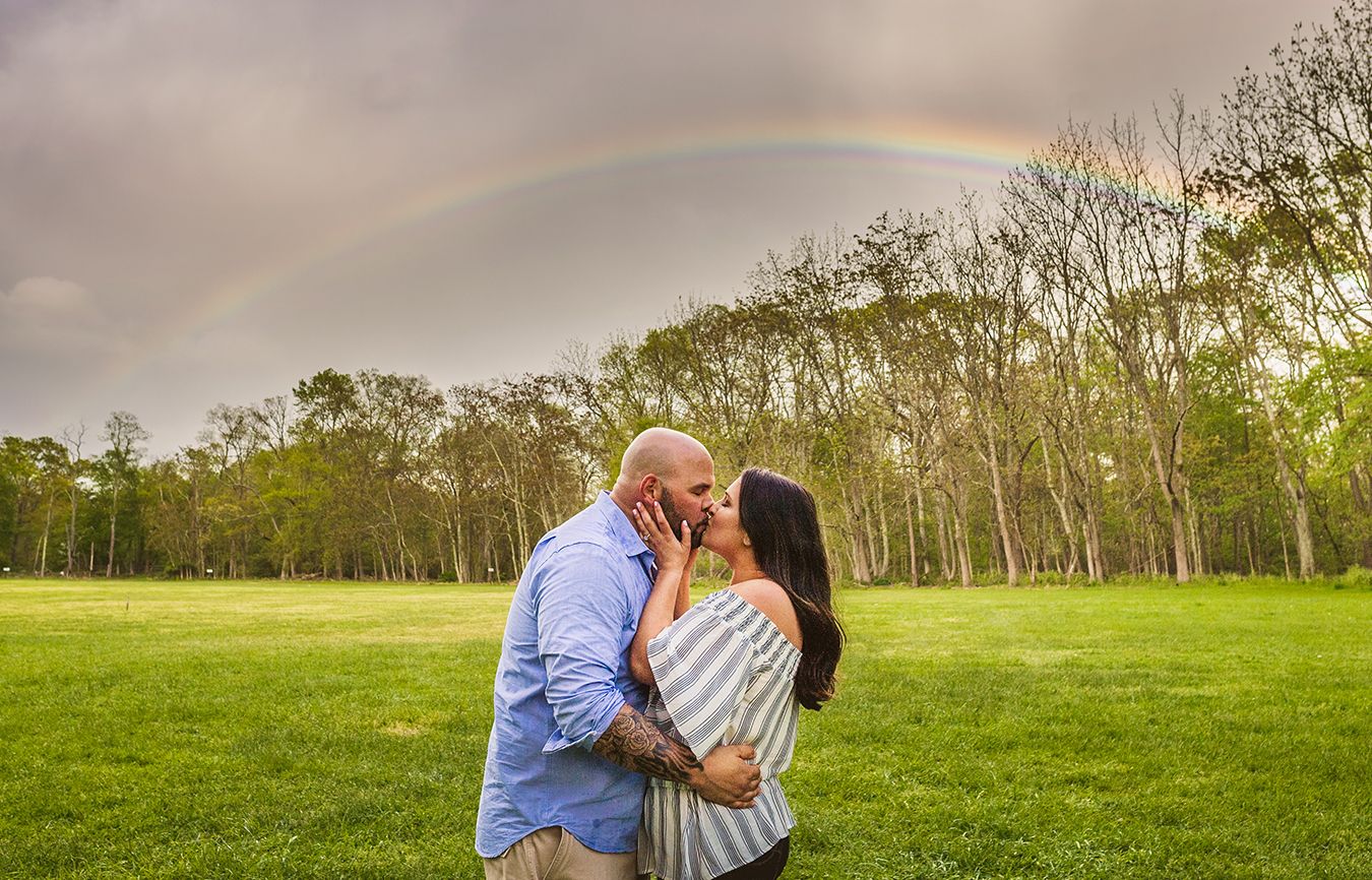 John and Courtney kiss in front of the heavenly rainbow