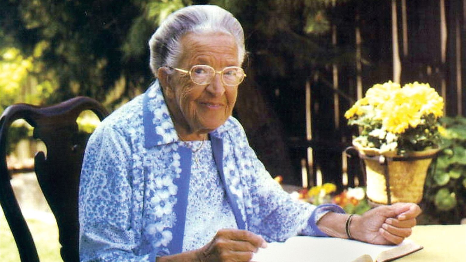 A portrait of Corrie ten Boom sitting outside on a warm day.