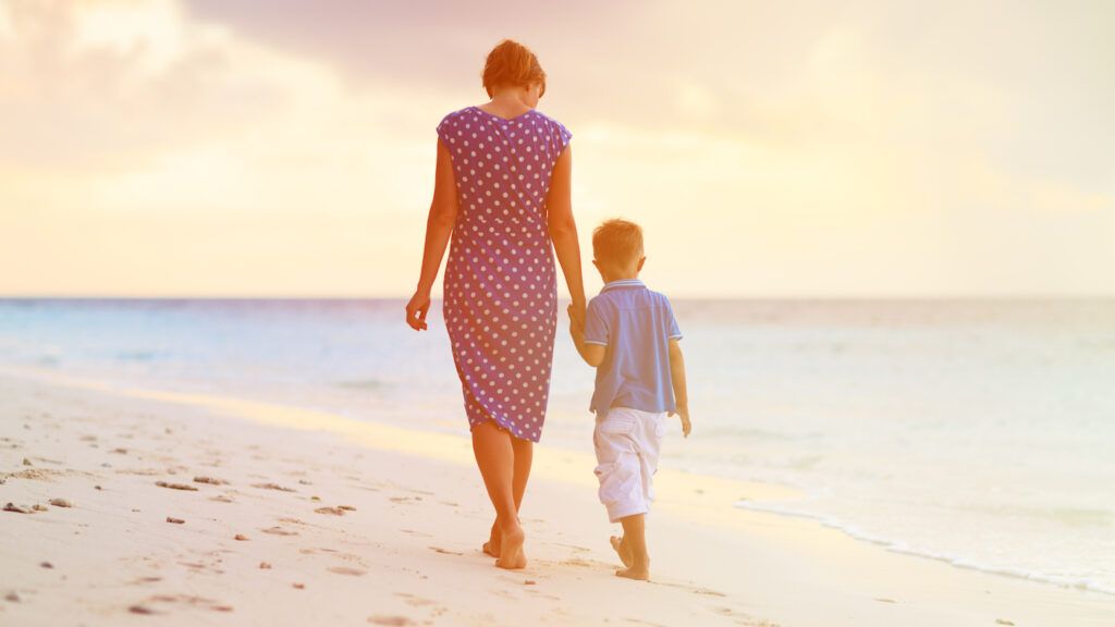 Mother and son walking on beach