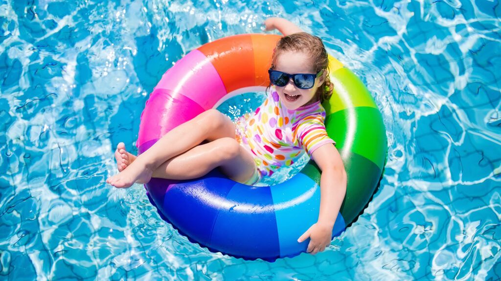 A young girl lounges on a float in a swimming pool