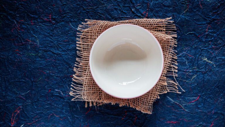 An empty bowl on blue background showing bible verses for fasting