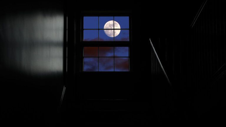 A full moon viewed through a window