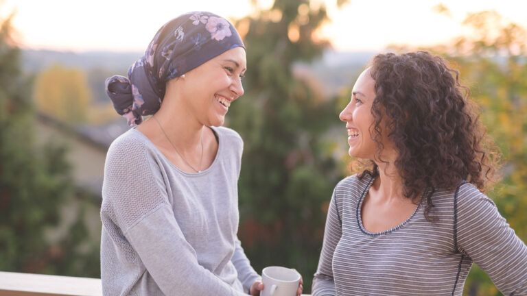A woman with cancer receives encouragement from her friend