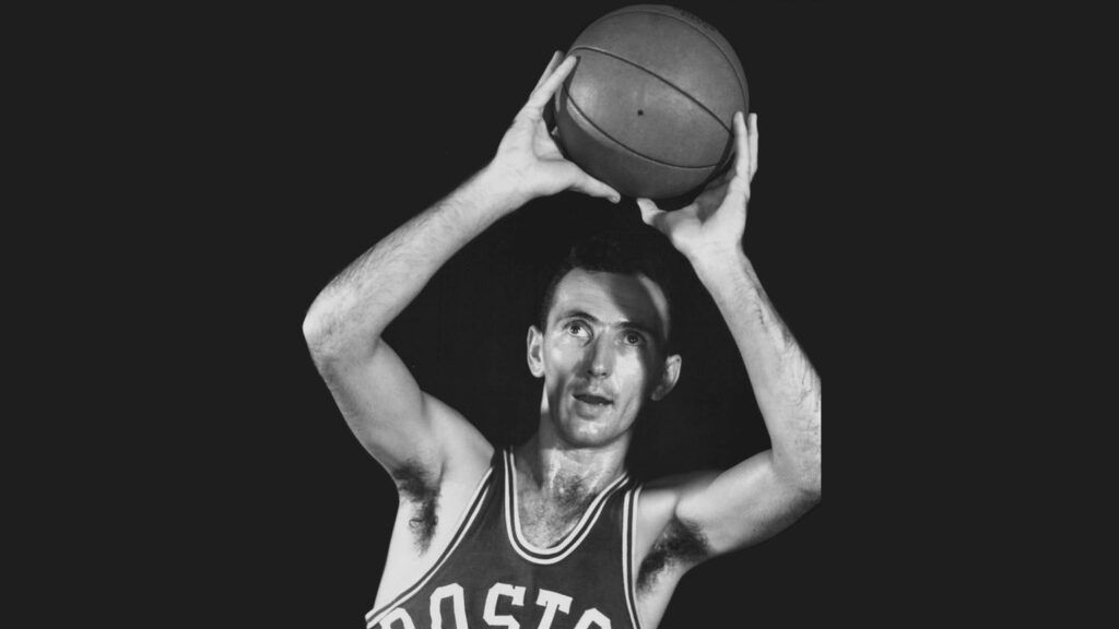 A black and white photo of Bob Cousy in action.