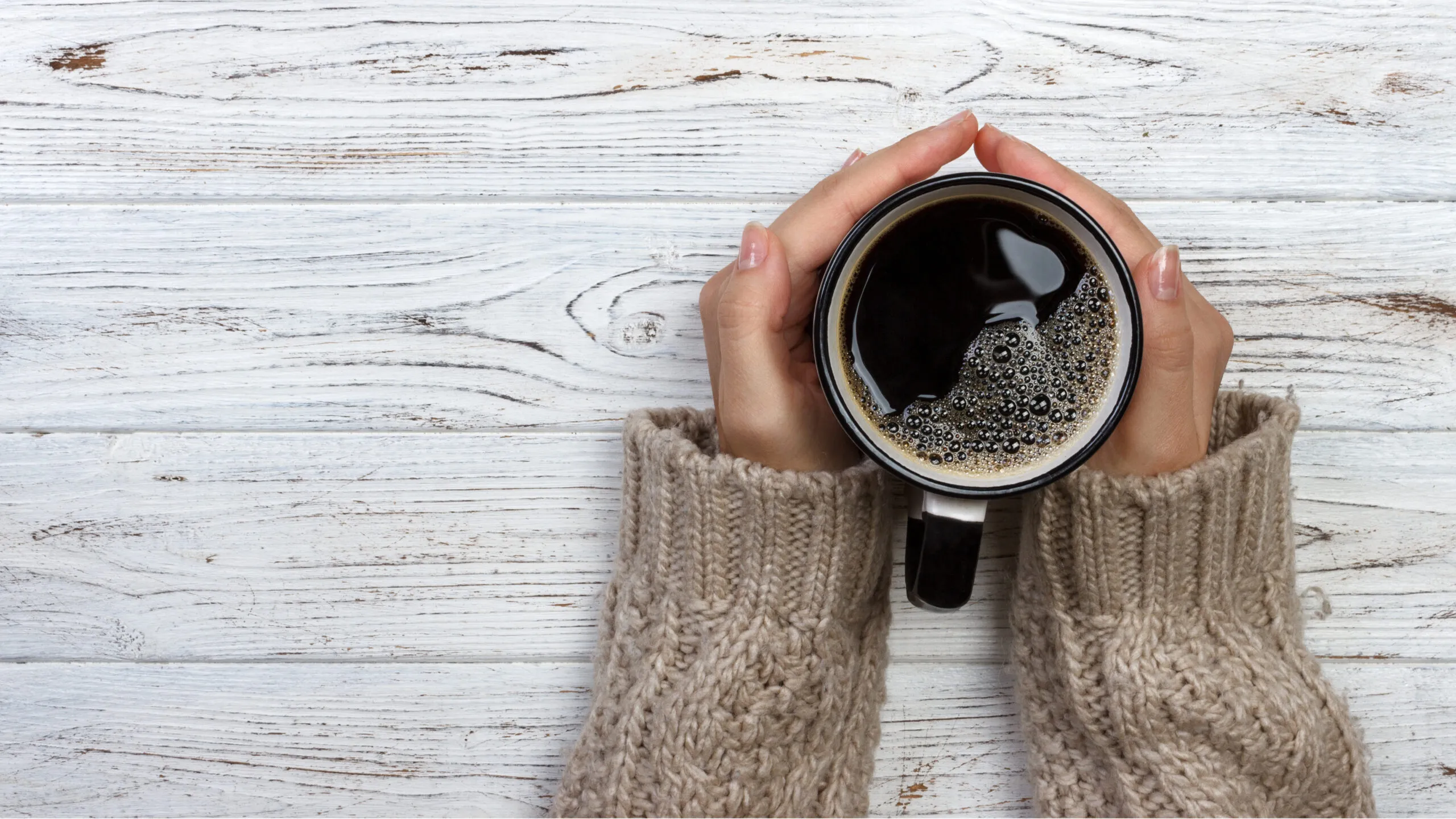 Hands grasping a cup of coffee