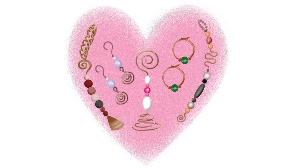 A pink heart with assorted handmade jewelry.