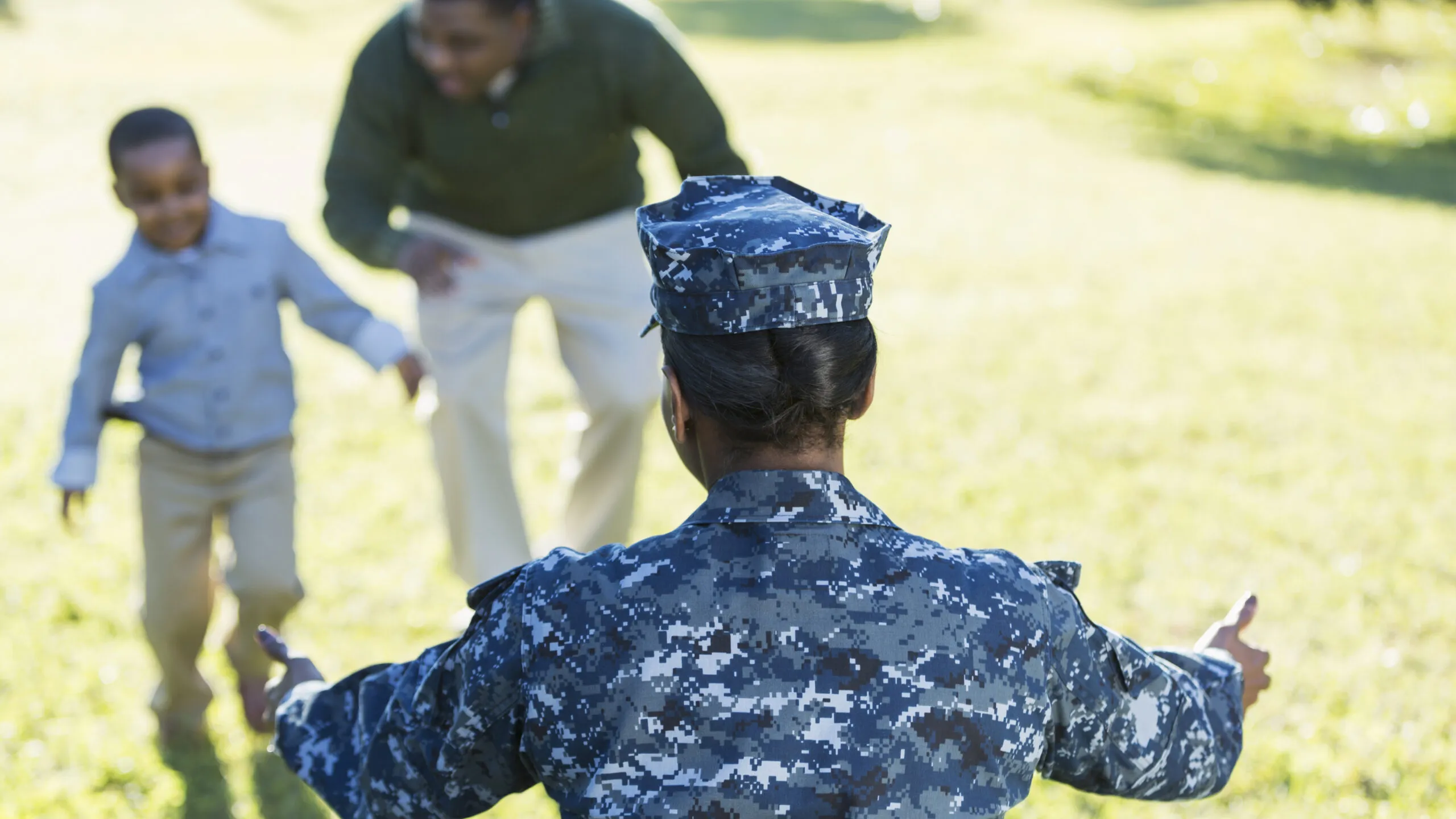 Military member opens arms to hug child