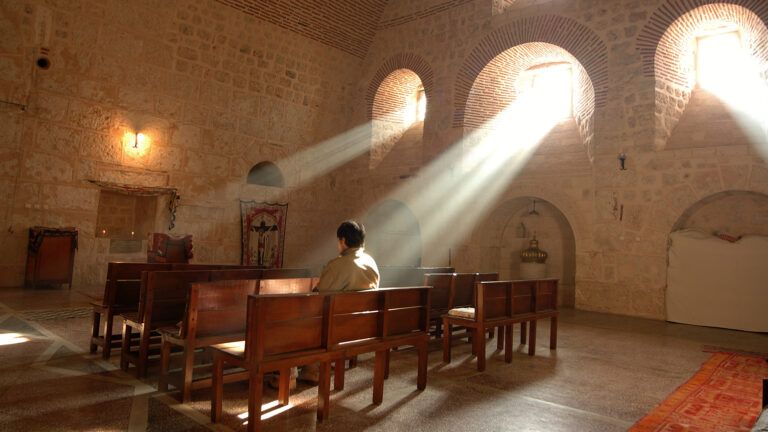 A man prays alone in a chapel
