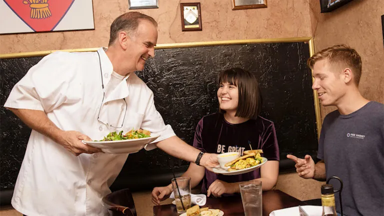 Sean Cummings serves a pair of happy customers at his restaurant